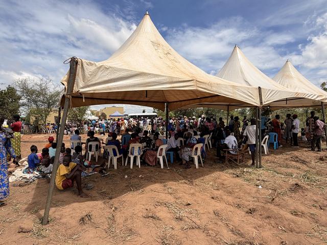 The community waiting under tents for care