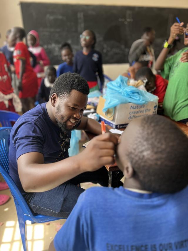 Checking a schoolboy’s teeth in the classroom