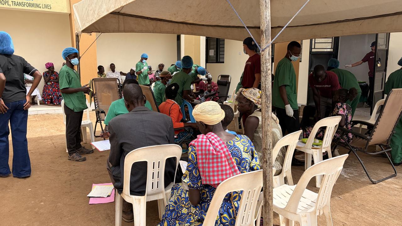 Patients waiting under a tent outside the Okwici Outreach Community Center during an outreach clinic