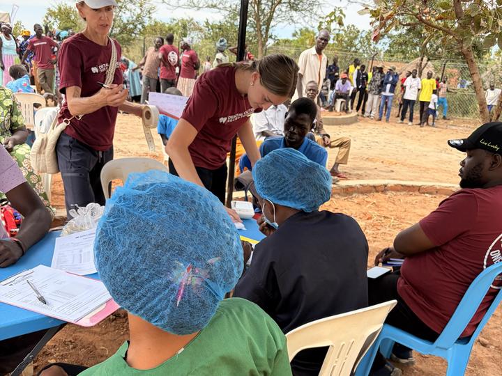 Team members recording patient details at a registration desk during an outreach